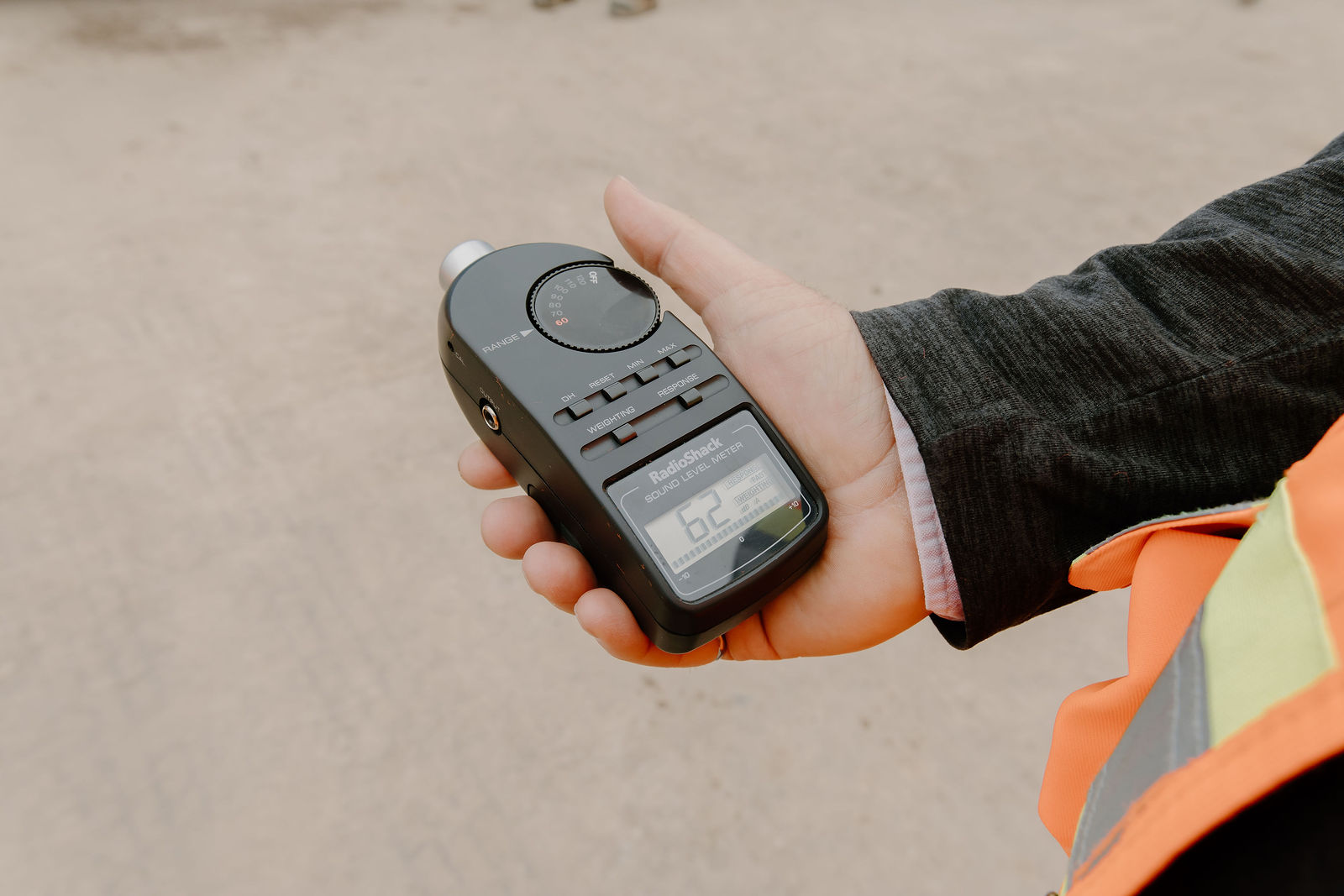 A sound level meter held up during testing of the hybrid hydrovac truck